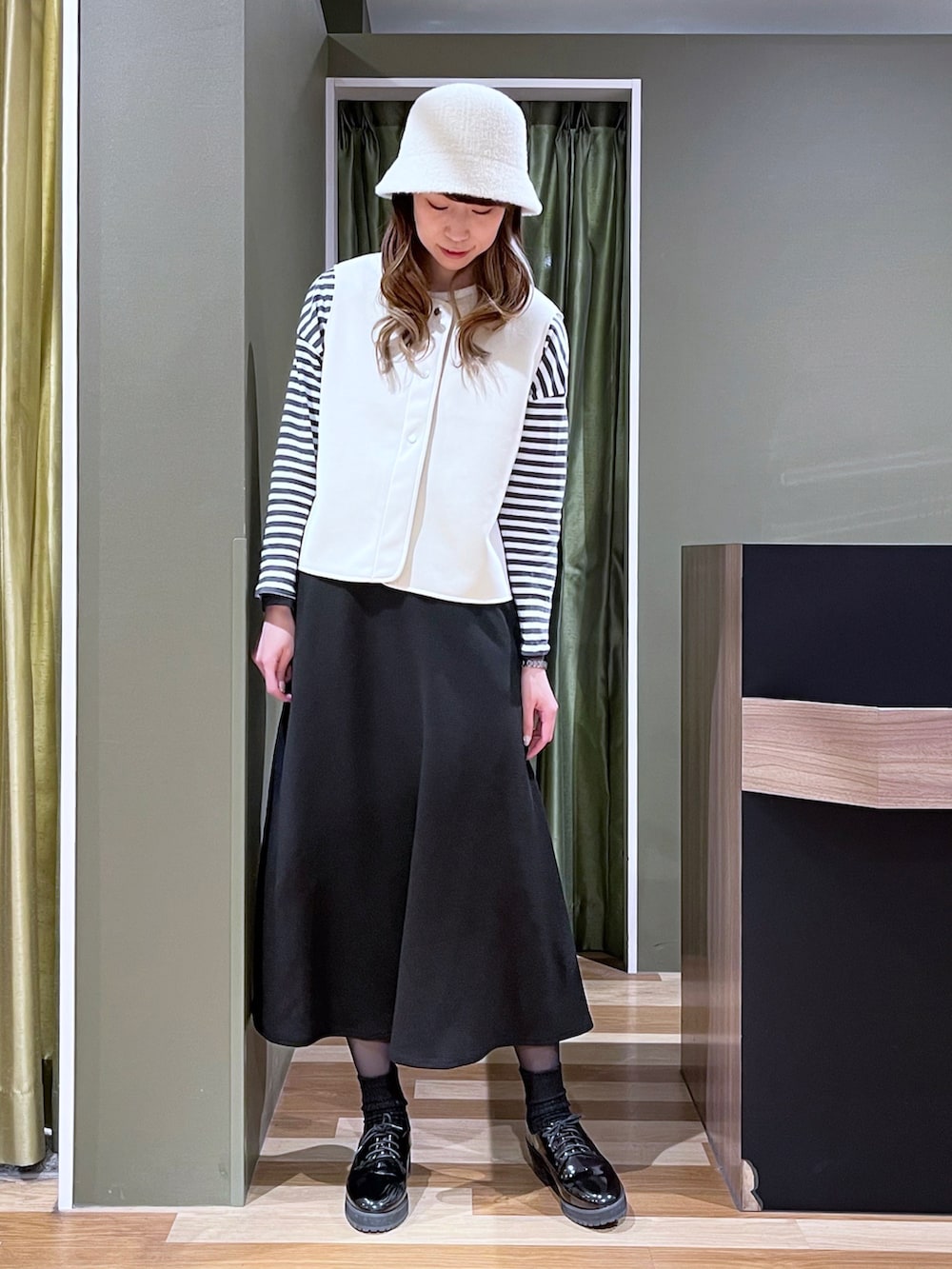 グレー系のTシャツ/カットソー、ホワイト系のトートバッグ、ベージュ系のベストを着用したレディースの冬コーディネートの5枚目の写真