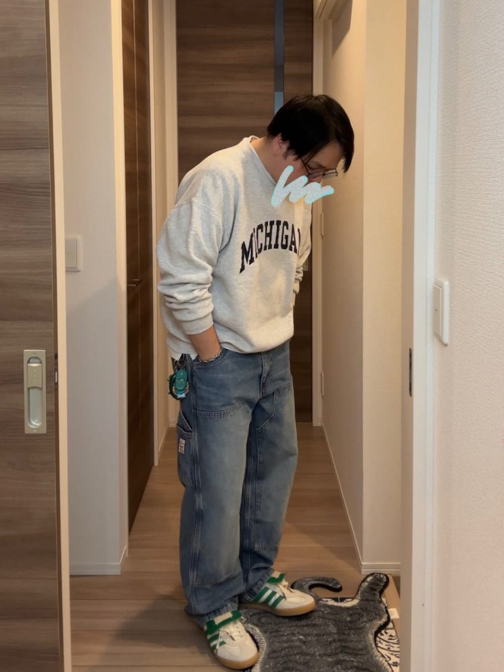 ブルー系のデニムパンツ、ホワイト系のスニーカー、グレー系のスウェットを着用したメンズの春コーディネートの3枚目の写真