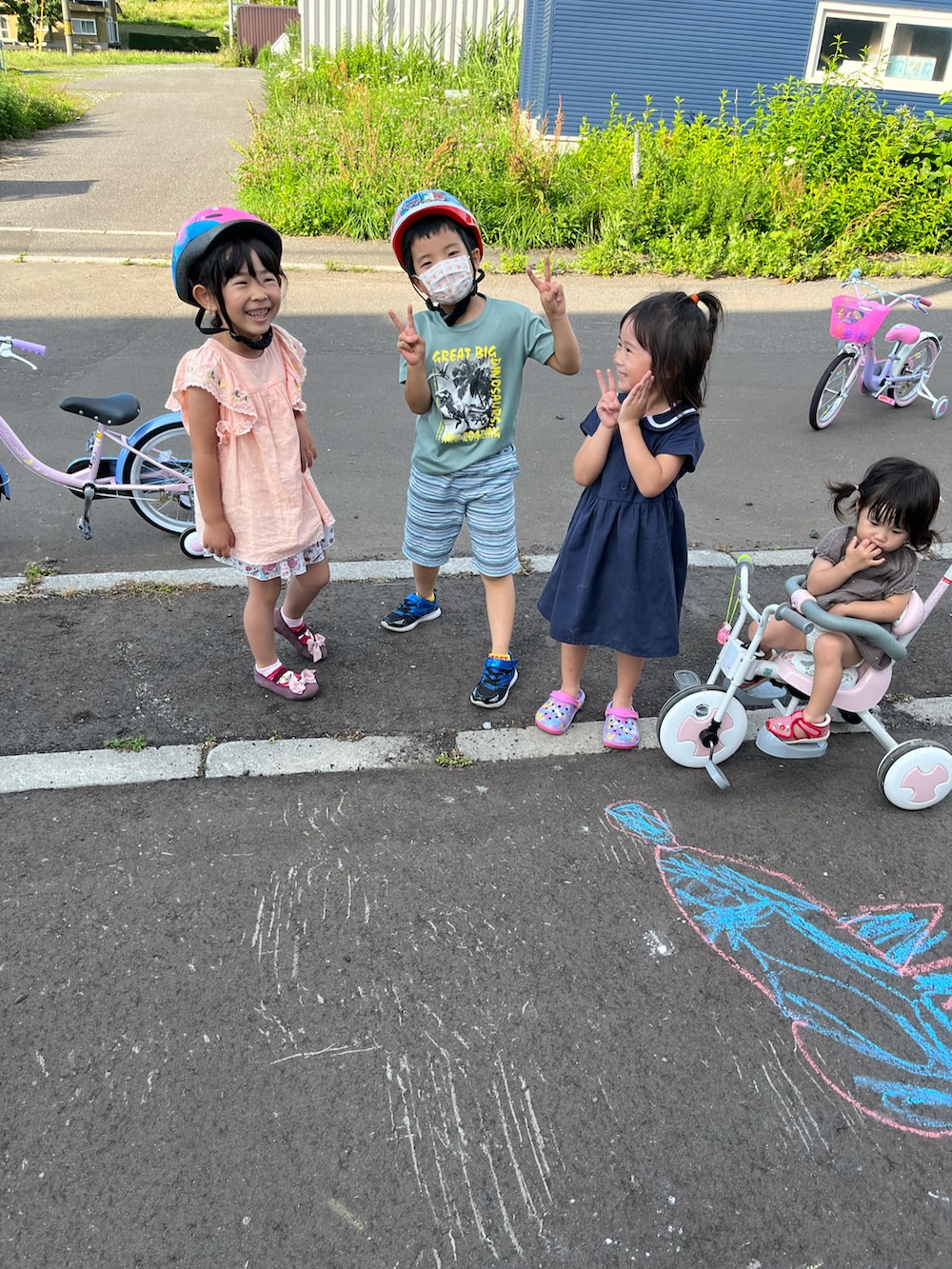 ピンク系のチュニック、レッド系のパンプスを着用したキッズの夏コーディネートの2枚目の写真