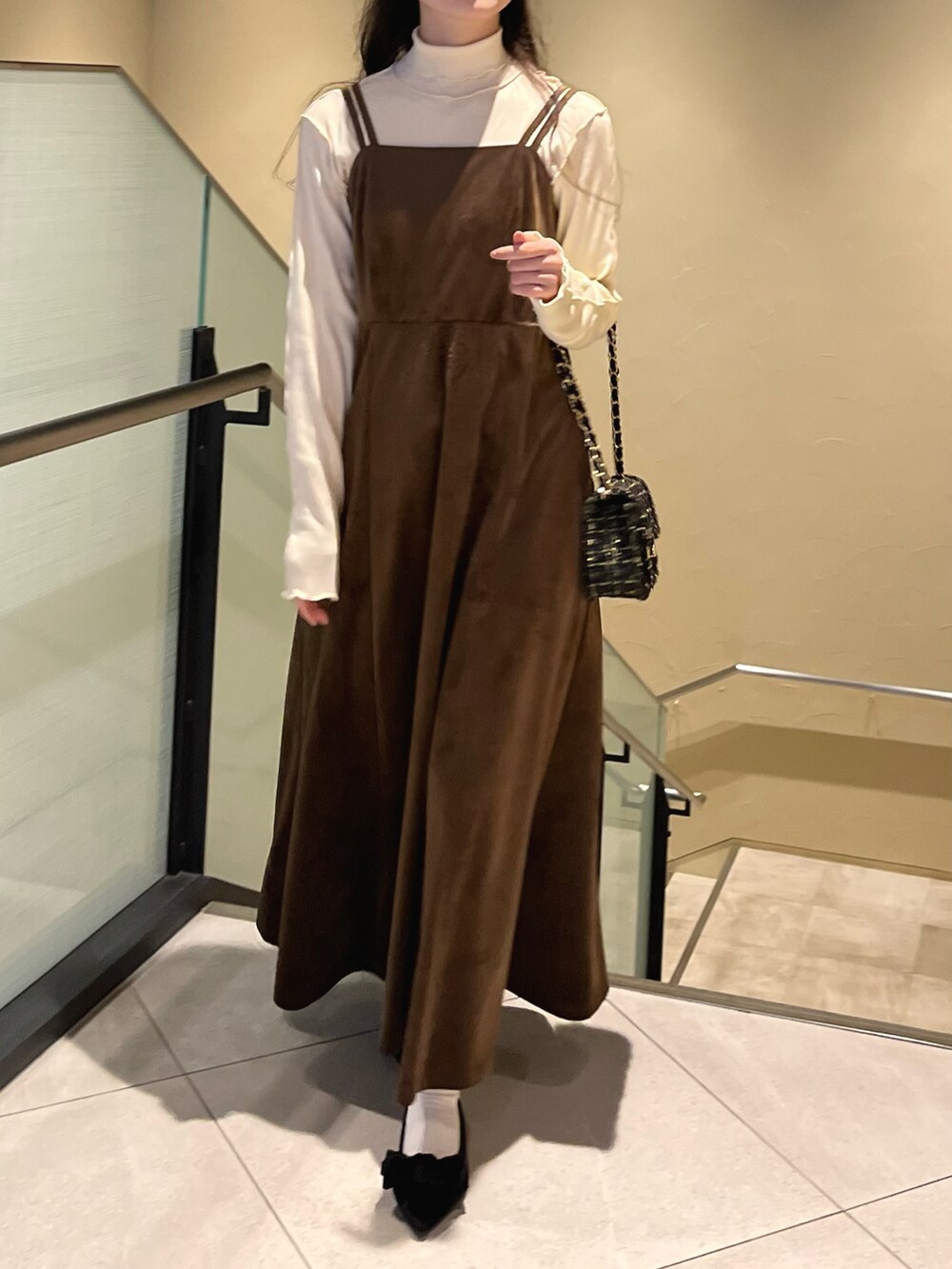 ブラウン系のワンピース、ブラック系のパンプス、ブラック系のショルダーバッグを着用したレディースの秋コーディネートの2枚目の写真