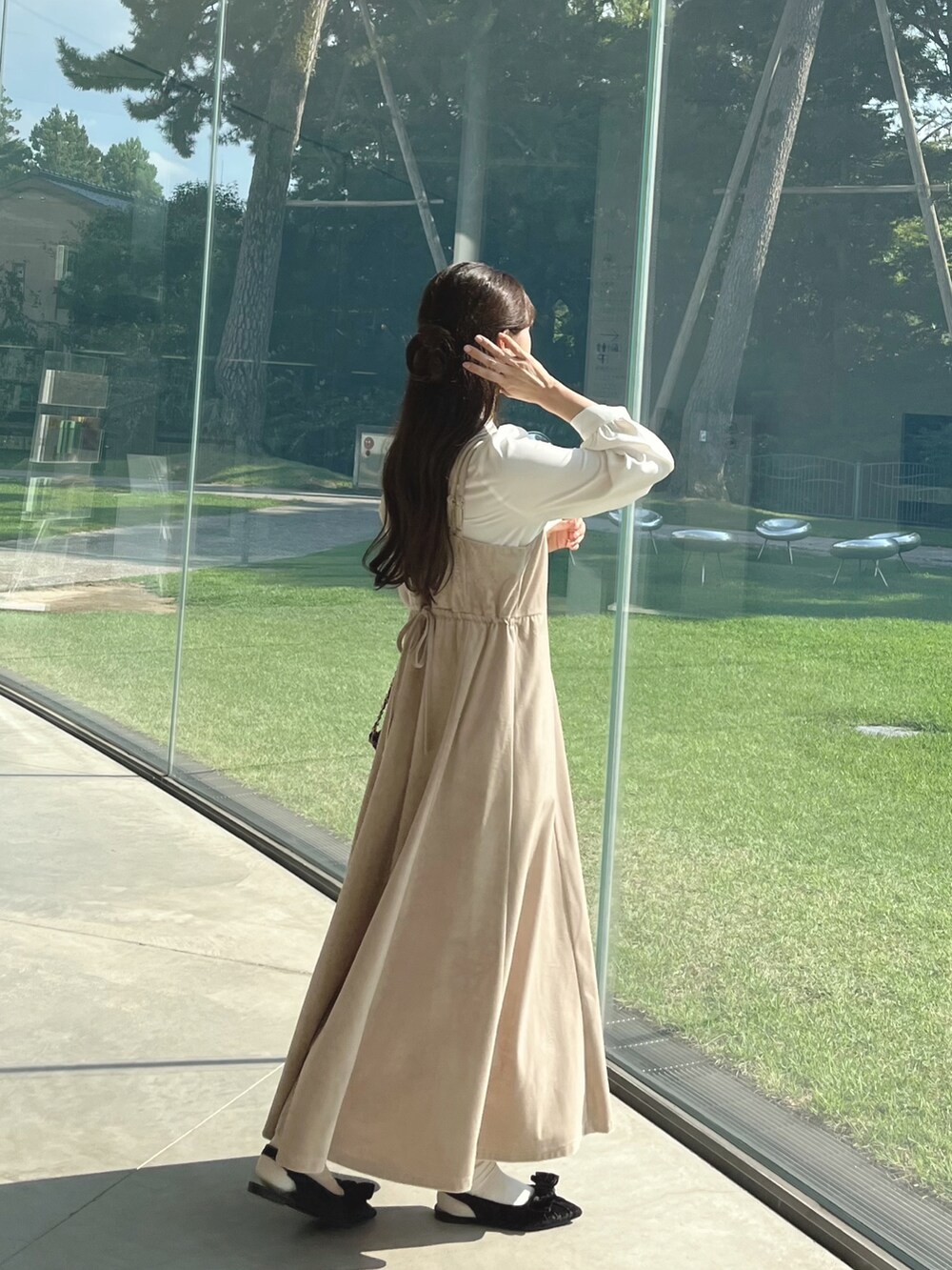 ホワイト系のワンピース、ブラック系のパンプス、ブラック系のショルダーバッグを着用したレディースの秋コーディネートの4枚目の写真