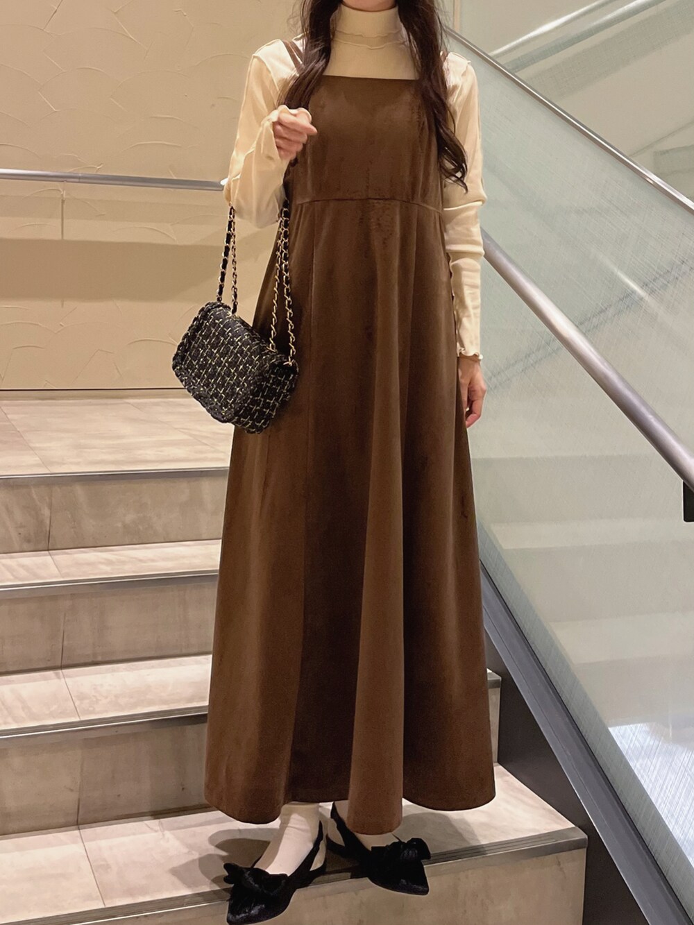 ブラウン系のワンピース、ブラック系のパンプス、ブラック系のショルダーバッグを着用したレディースの秋コーディネートの4枚目の写真