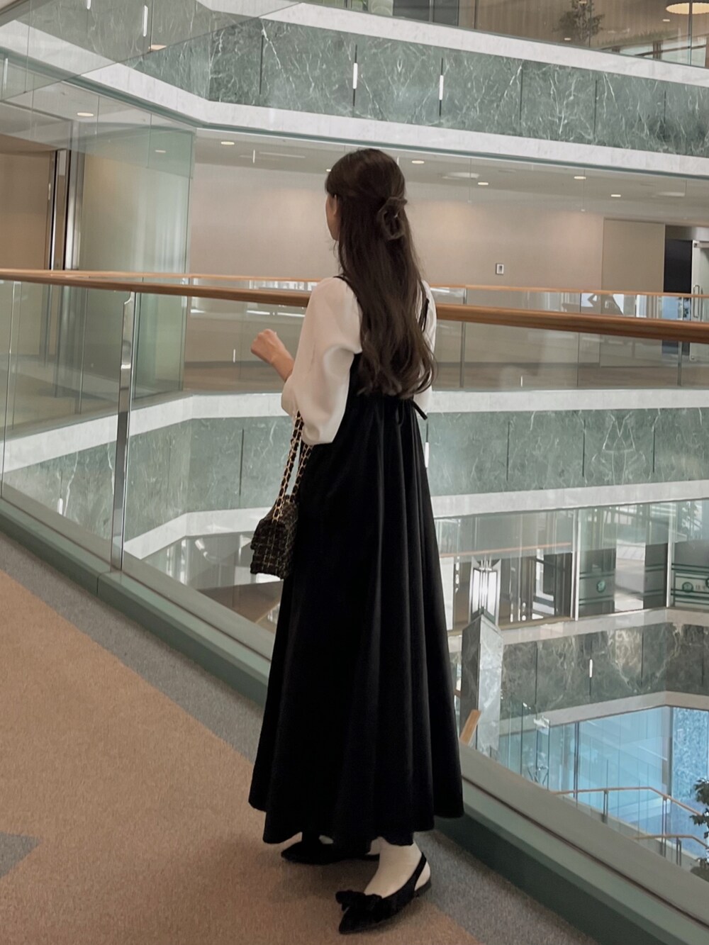 ブラック系のワンピース、ブラック系のパンプス、ホワイト系のシャツ/ブラウスを着用したレディースの秋コーディネートの3枚目の写真