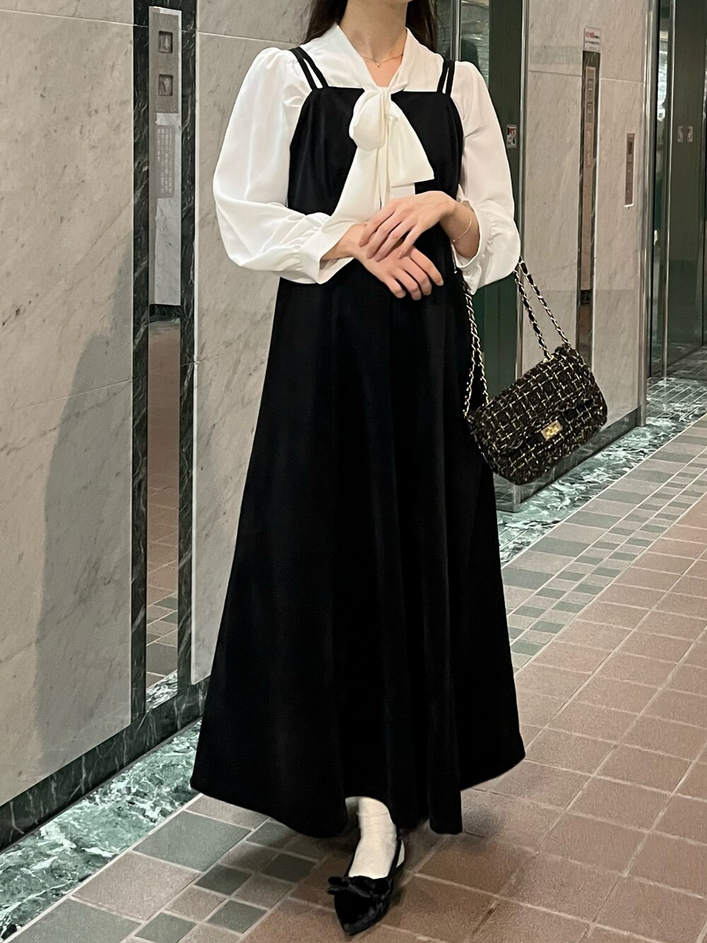 ブラック系のワンピース、ブラック系のパンプス、ホワイト系のシャツ/ブラウスを着用したレディースの秋コーディネートの5枚目の写真