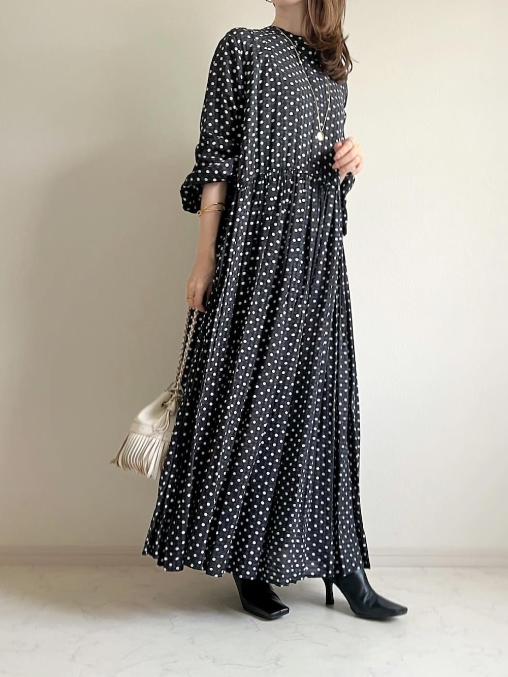 ホワイト系のショルダーバッグ、ブラック系のワンピース、グリーン系のカーディガン/ボレロを着用したレディースの秋コーディネートの2枚目の写真