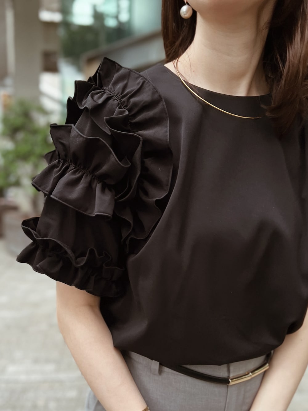 ブラック系のTシャツ/カットソー、グレー系のパンツ、ホワイト系のパンプスを着用したレディースの春コーディネートの2枚目の写真