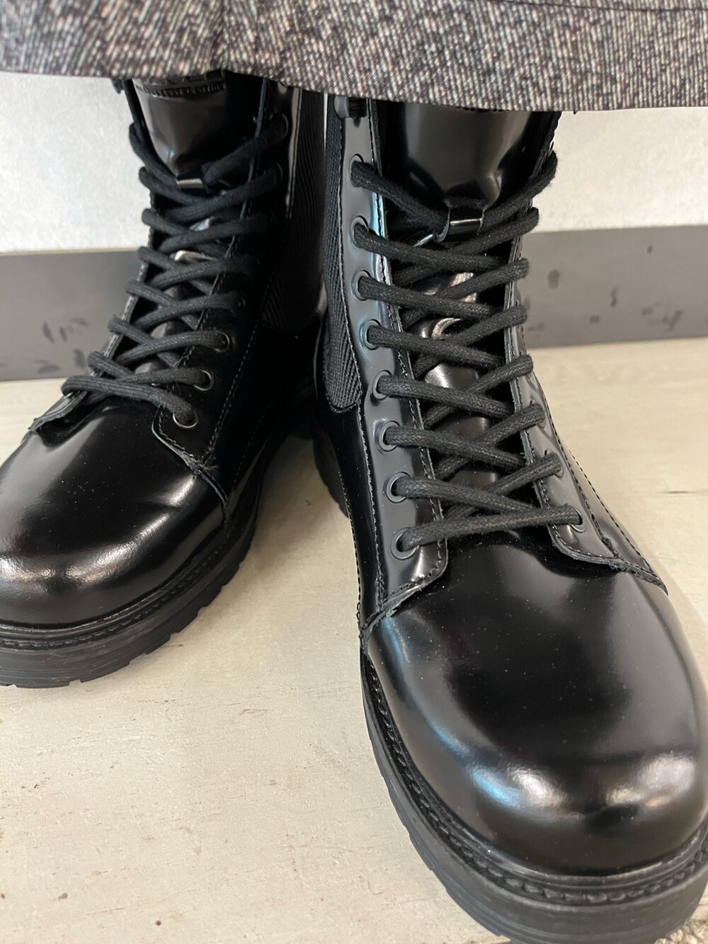 レッド系のショルダーバッグ、ブラック系のブーツ、ブラック系のスカートを着用したレディースの秋コーディネートの3枚目の写真