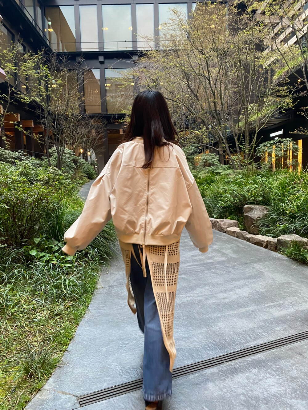 ベージュ系のワンピース、ホワイト系のTシャツ/カットソー、ベージュ系のブルゾンを着用したレディースの春コーディネートの2枚目の写真