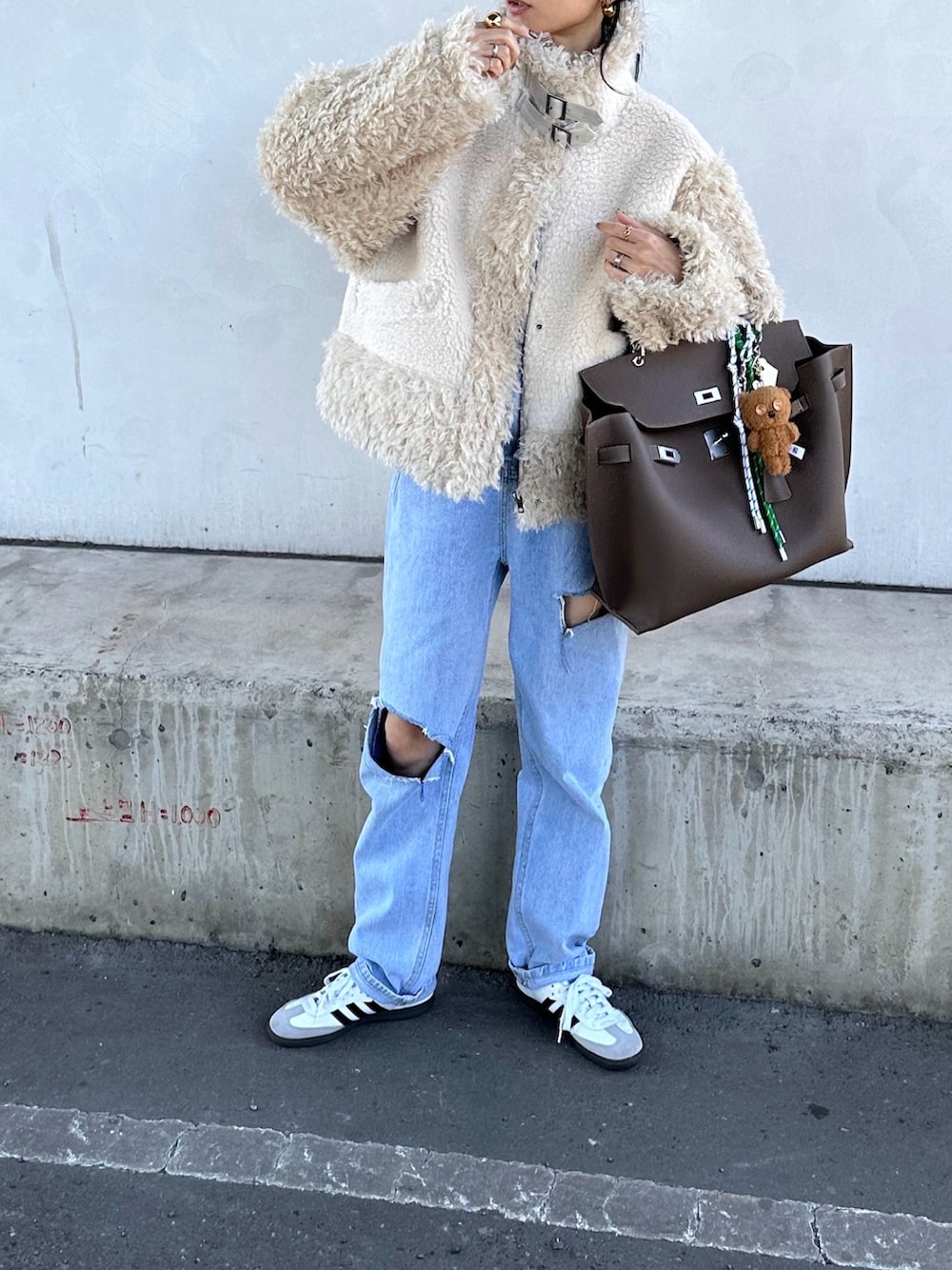 ホワイト系のムートンコートを着用したレディースの秋コーディネートの2枚目の写真