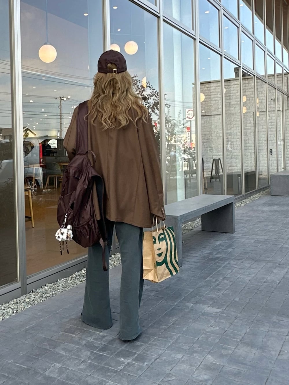 ブラウン系のテーラードジャケット、ブラウン系のバックパック/リュック、グレー系のスウェットパンツを着用したレディースの春コーディネートの4枚目の写真