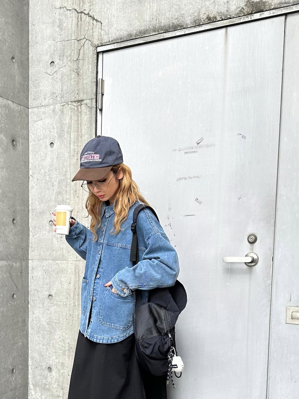 ブルー系のデニムジャケット、ブラック系のワンピースを着用したレディースの冬コーディネートの2枚目の写真