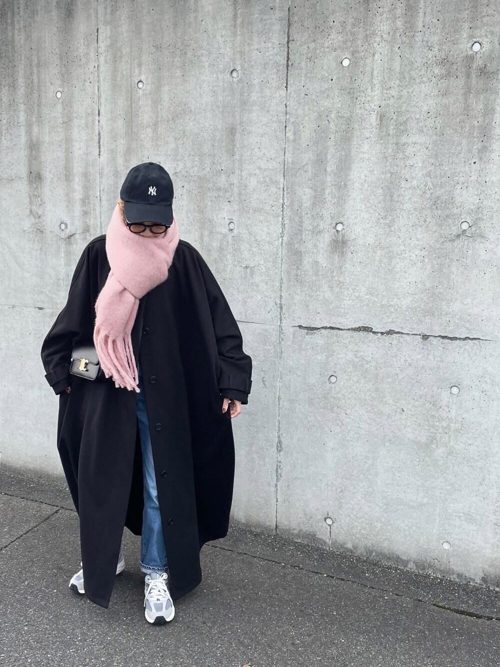 ベージュ系のステンカラーコート、ピンク系のストール/ショールを着用したレディースの冬コーディネートの2枚目の写真