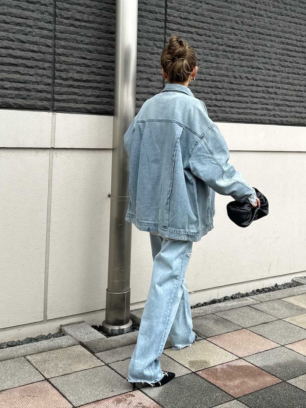 ブルー系のデニムジャケット、ブラック系のパンプスを着用したレディースの春コーディネートの5枚目の写真