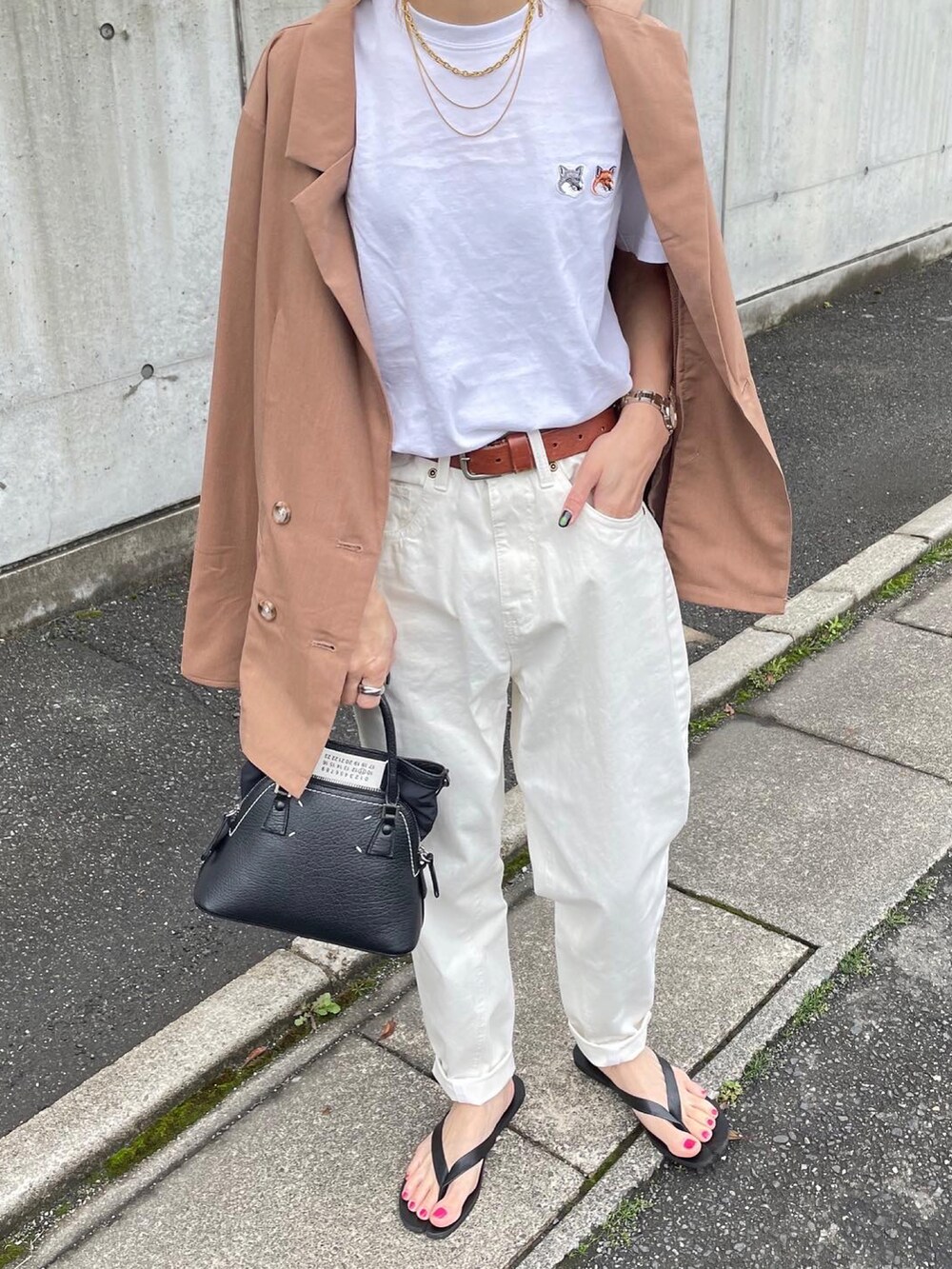 ブラック系のハンドバッグを着用したレディースの春コーディネートの2枚目の写真