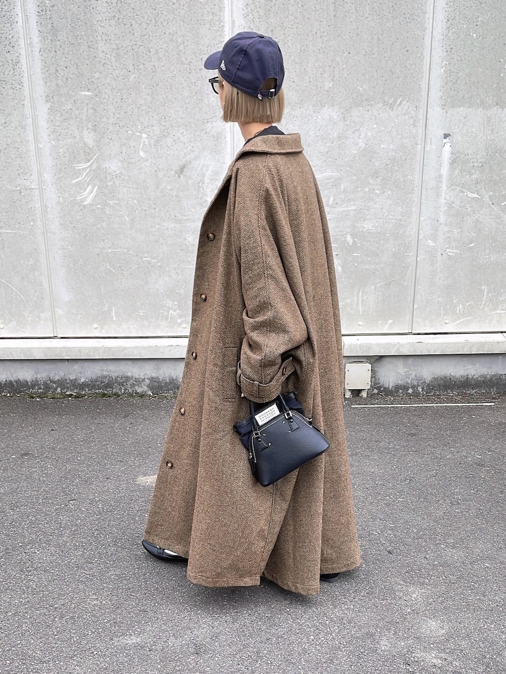 ベージュ系のステンカラーコートを着用したレディースの秋コーディネートの4枚目の写真
