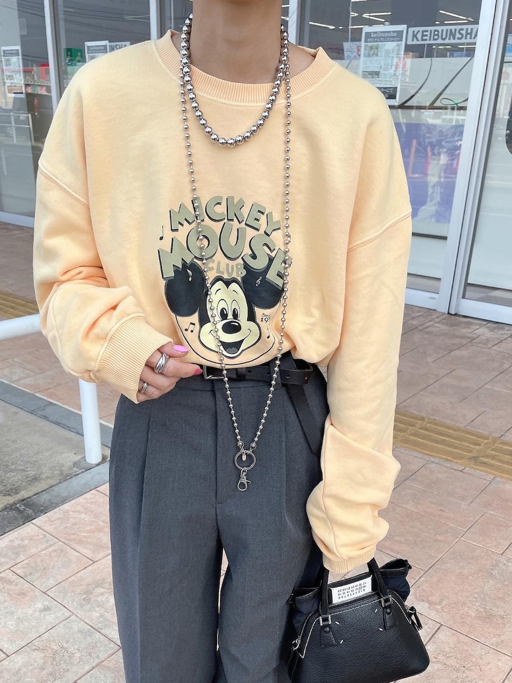 イエロー系のスウェットを着用したレディースの春コーディネートの2枚目の写真