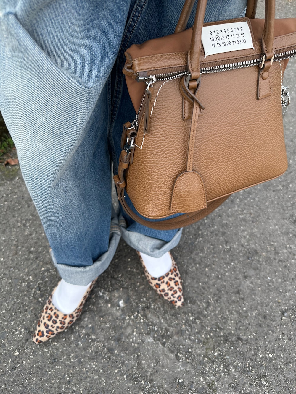 ブラック系のパンプスを着用したレディースの春コーディネートの3枚目の写真