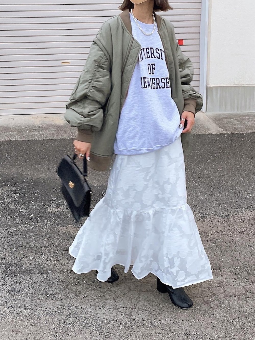 グリーン系のMA-1、ホワイト系のスカートを着用したレディースの秋コーディネートの2枚目の写真