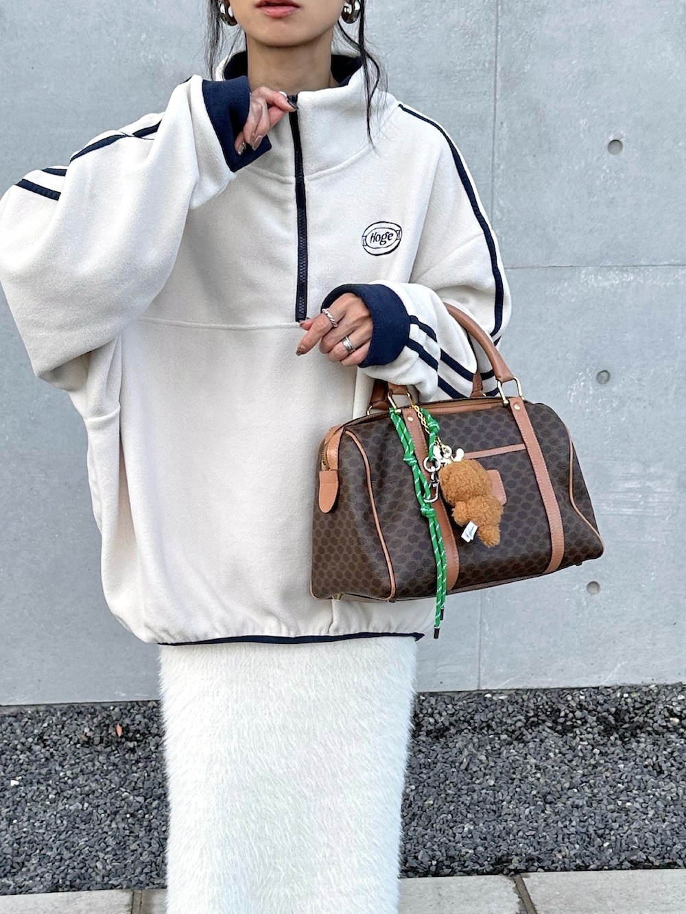 ベージュ系のスウェット、ホワイト系のスカート、ブラウン系のキャップを着用したレディースの秋コーディネートの2枚目の写真