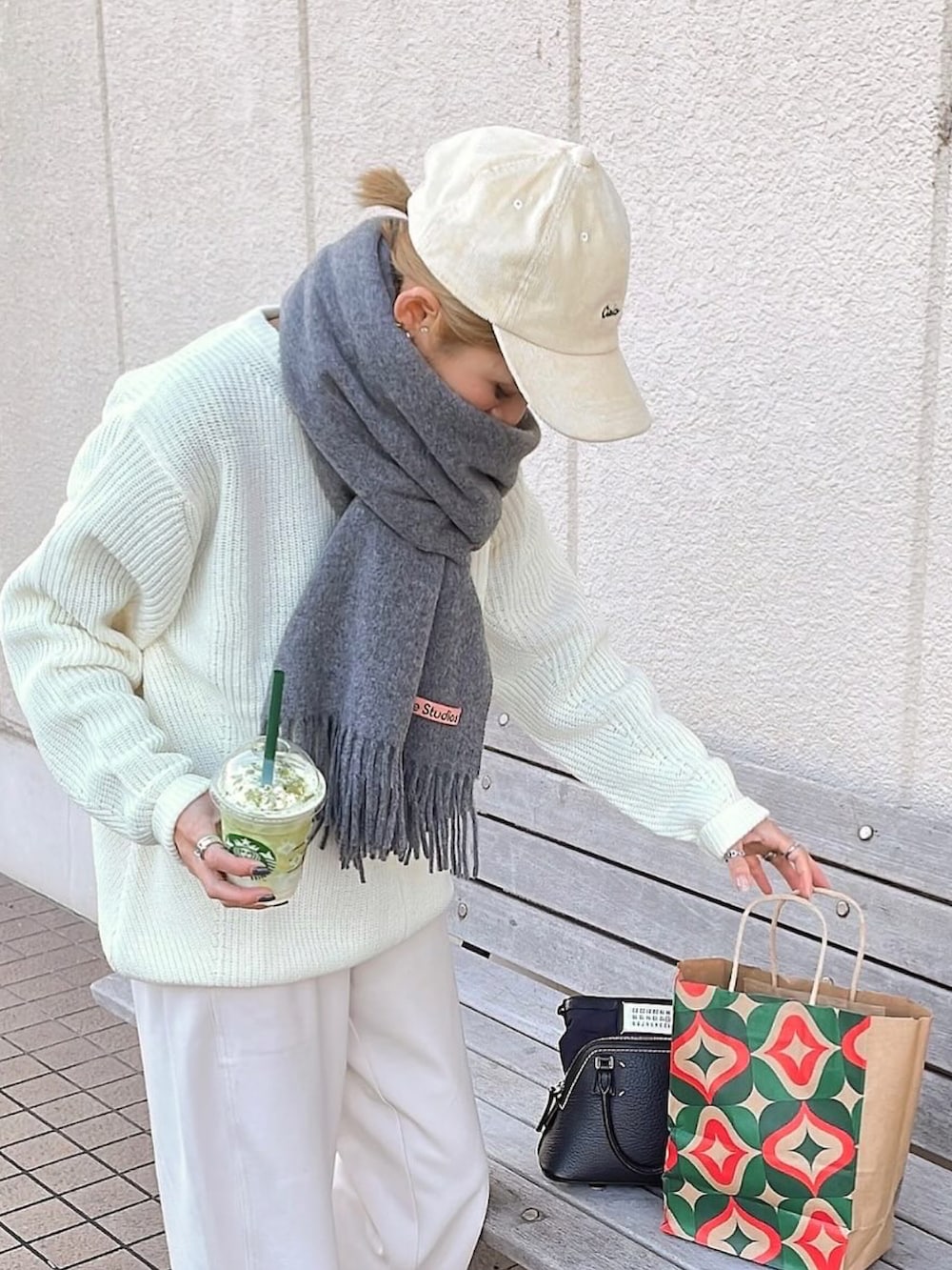 ホワイト系のその他パンツ、ホワイト系のニット/セーター、レッド系のスニーカーを着用したレディースの冬コーディネートの2枚目の写真