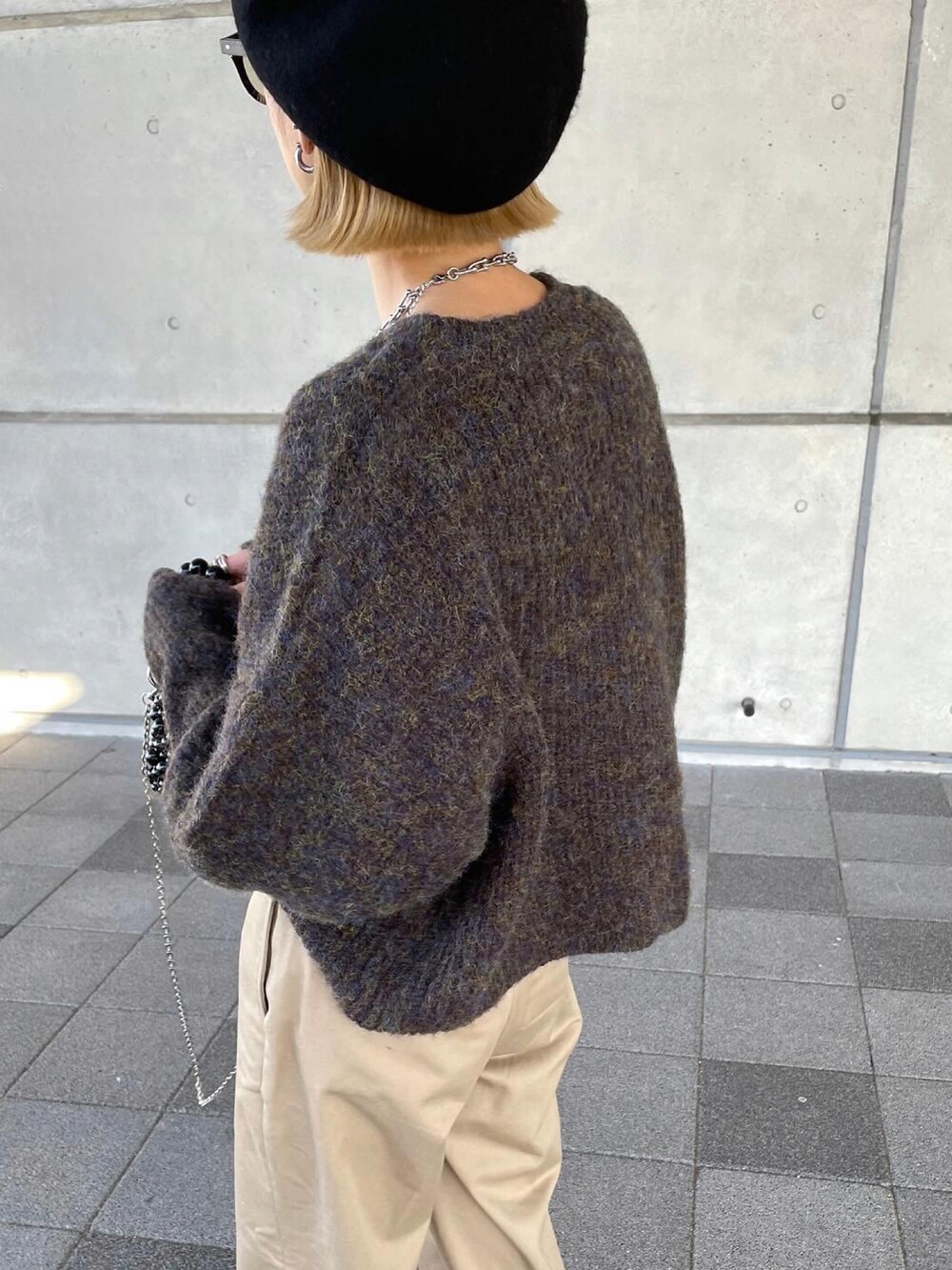 ブラウン系のニット/セーター、ベージュ系のチノパンツを着用したレディースの冬コーディネートの2枚目の写真