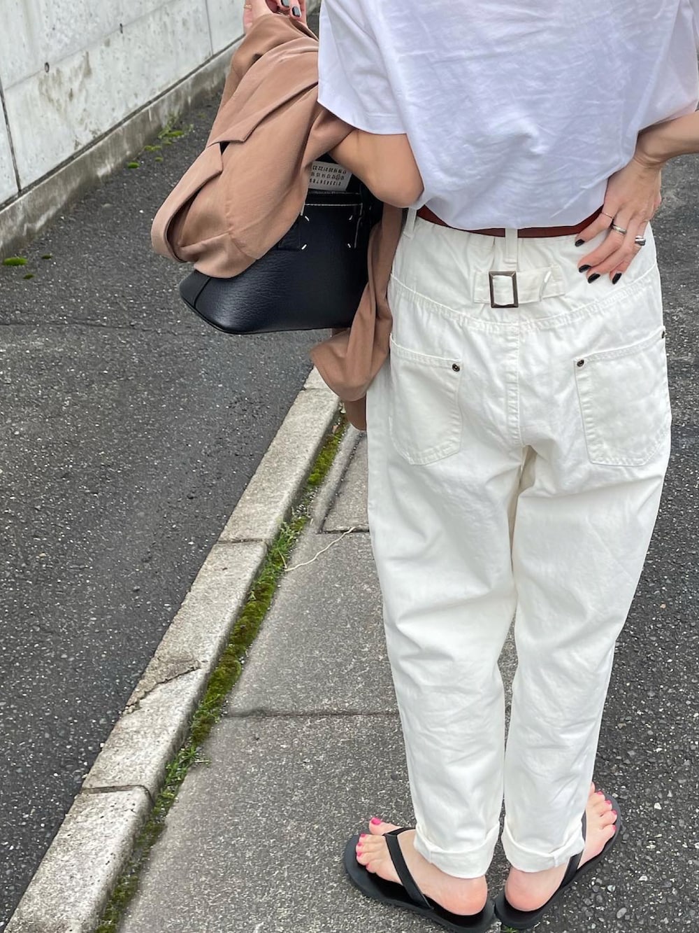 ブラック系のハンドバッグを着用したレディースの春コーディネートの3枚目の写真