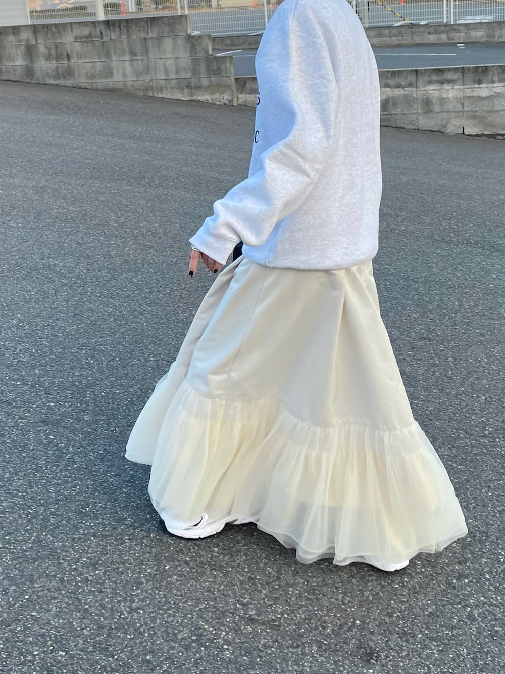 グレー系のスウェット、ホワイト系のワンピースを着用したレディースの冬コーディネートの2枚目の写真