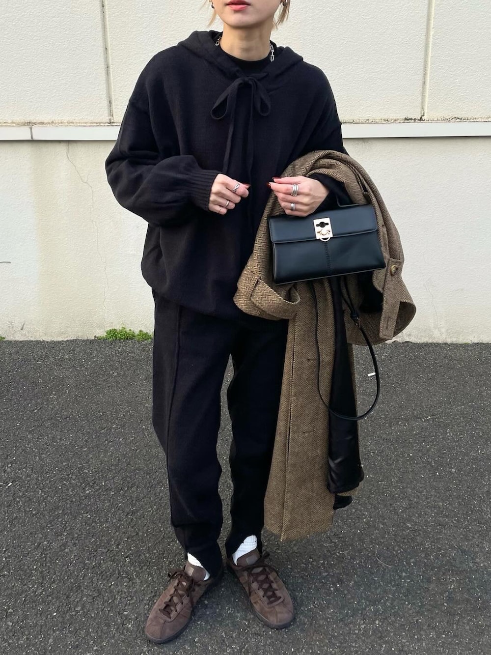 ベージュ系のステンカラーコートを着用したレディースの冬コーディネートの3枚目の写真