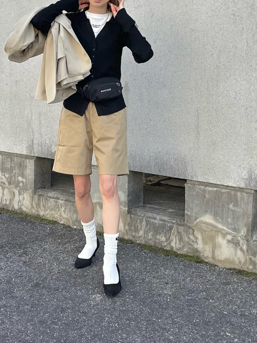 ブラック系のボディバッグ/ウエストポーチ、ベージュ系のテーラードジャケット、ブラック系のカーディガン/ボレロを着用したレディースの春コーディネートの4枚目の写真