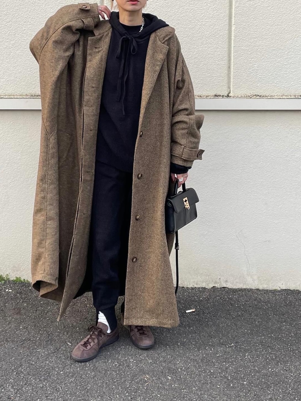 ベージュ系のステンカラーコートを着用したレディースの冬コーディネートの2枚目の写真