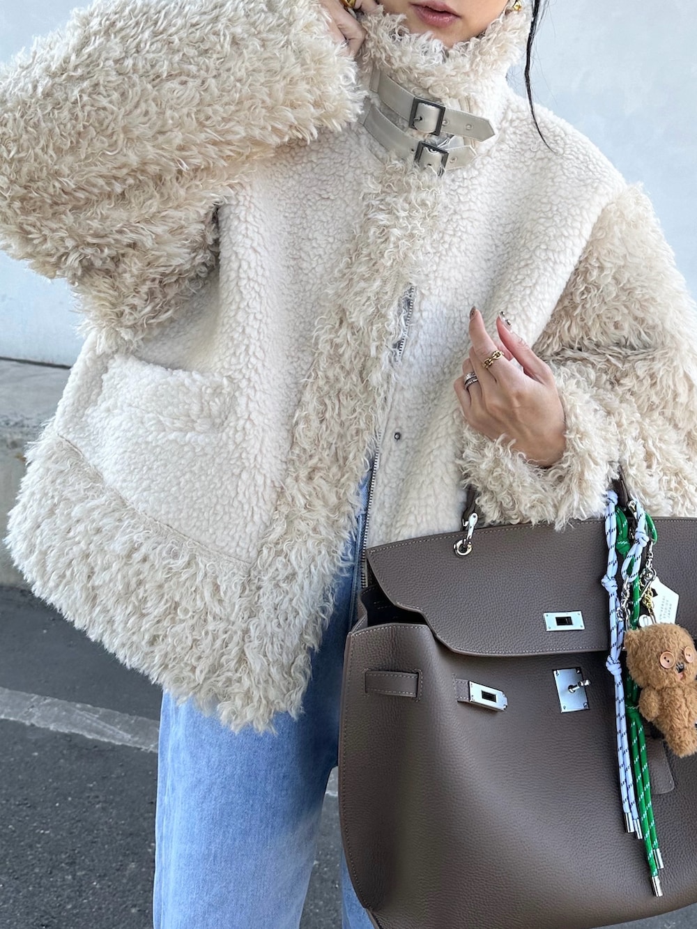 ホワイト系のムートンコートを着用したレディースの秋コーディネートの3枚目の写真