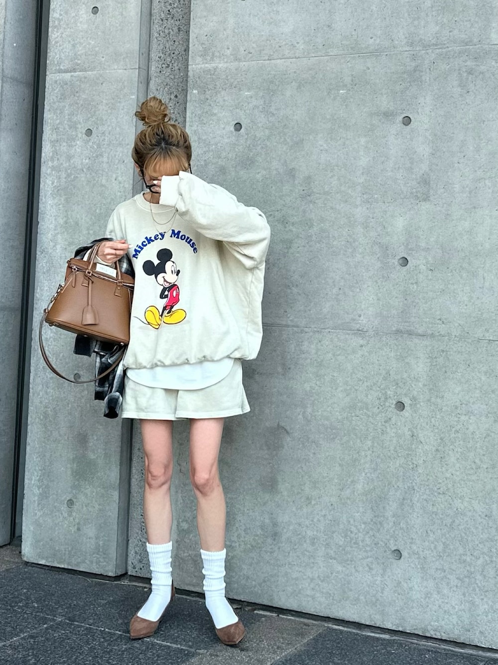 ブラウン系のバッグを着用したレディースの春コーディネートの4枚目の写真