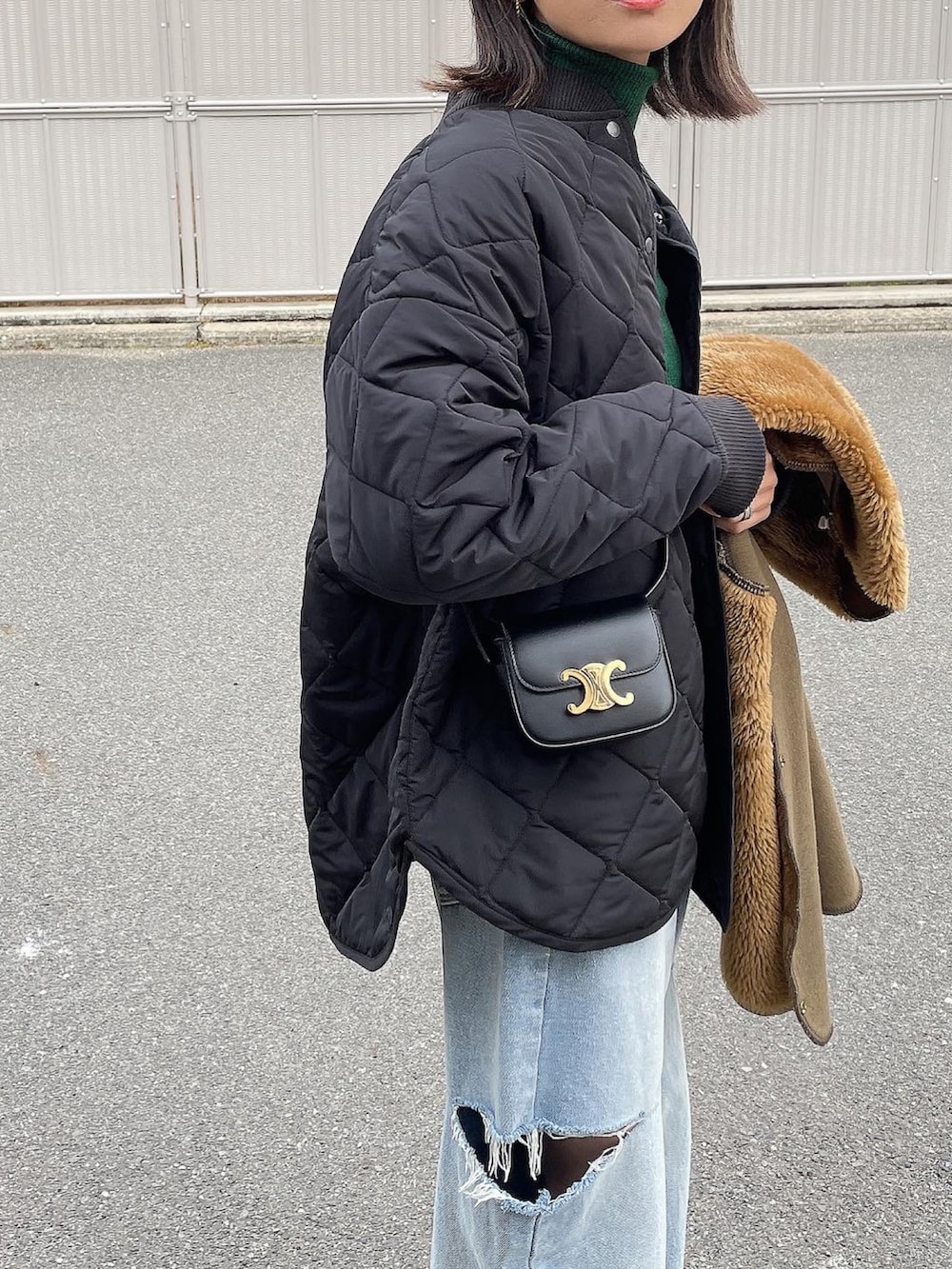 ブラック系のブルゾンを着用したレディースの冬コーディネートの2枚目の写真