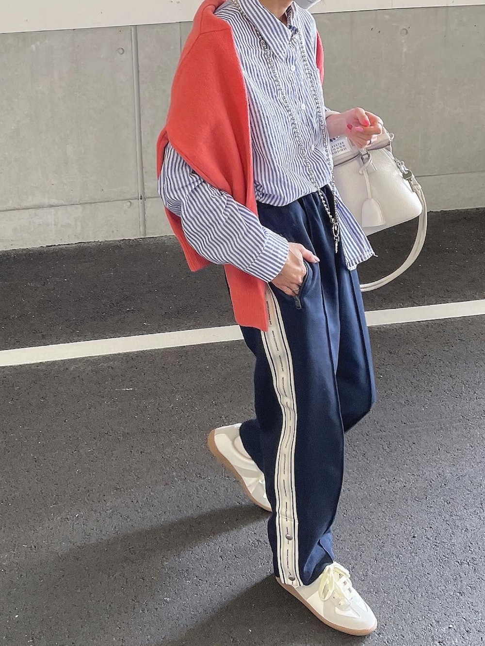 ホワイト系のスニーカーを着用したレディースの春コーディネートの3枚目の写真