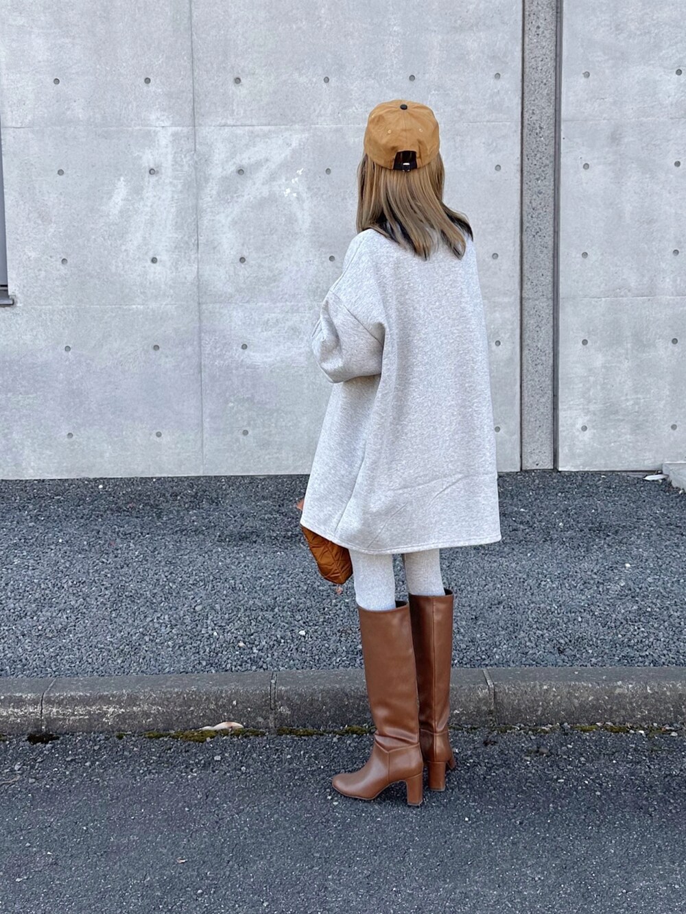 グレー系のスウェット、ベージュ系のキャップを着用したレディースの冬コーディネートの3枚目の写真