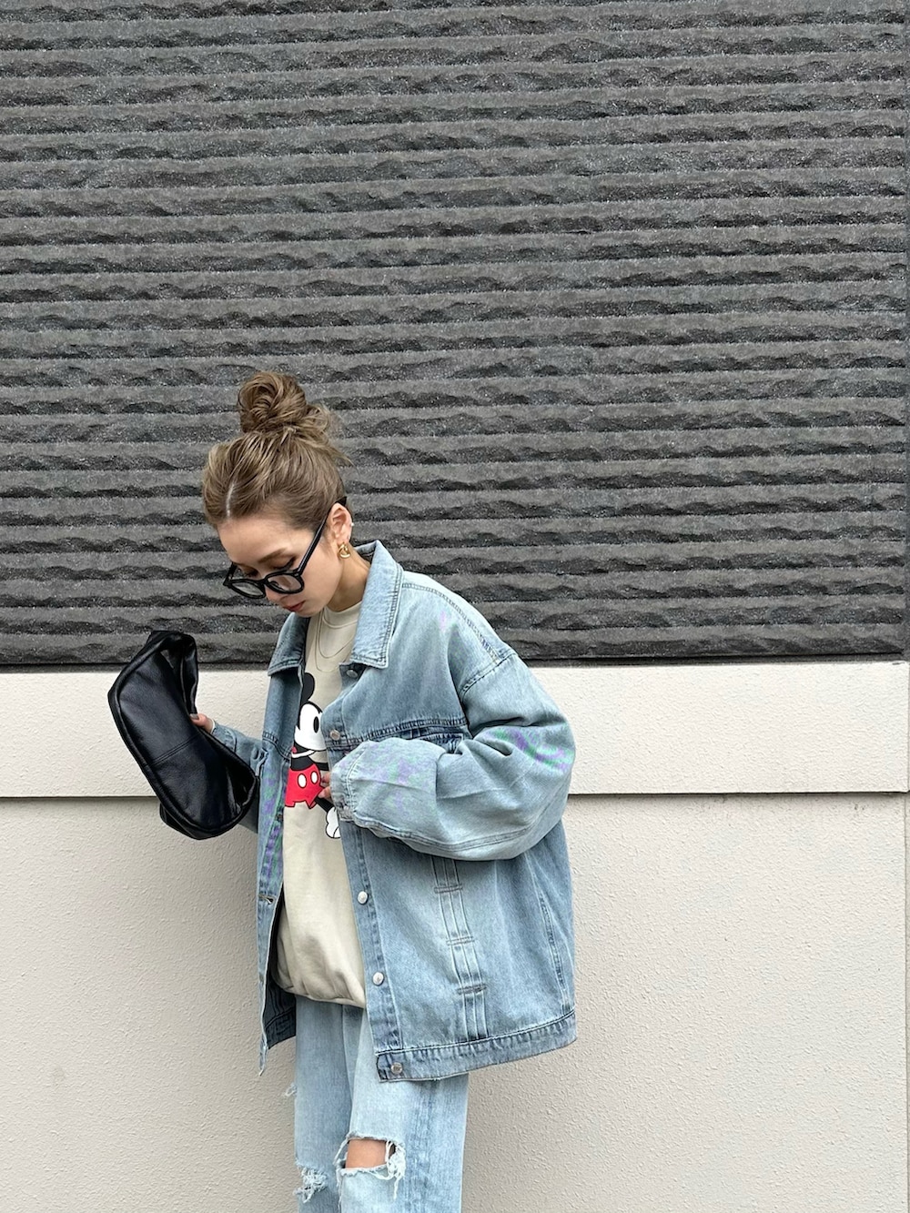 ブルー系のデニムジャケット、ブラック系のパンプスを着用したレディースの春コーディネートの3枚目の写真