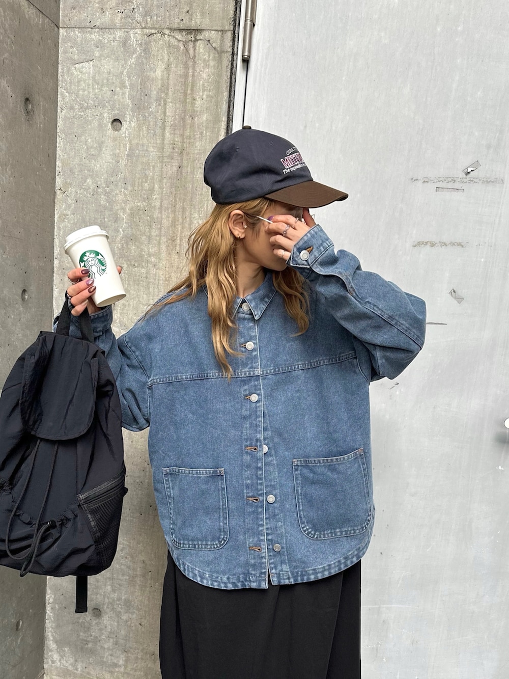 ブルー系のデニムジャケット、ブラック系のワンピースを着用したレディースの冬コーディネートの3枚目の写真