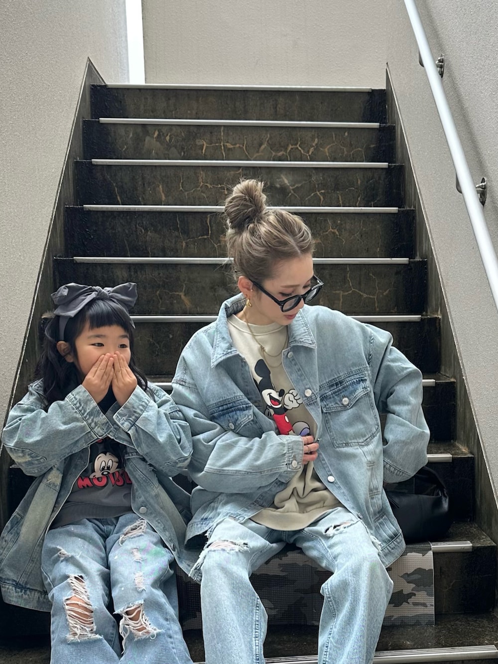 ブルー系のデニムジャケット、ブラック系のパンプスを着用したレディースの春コーディネートの2枚目の写真