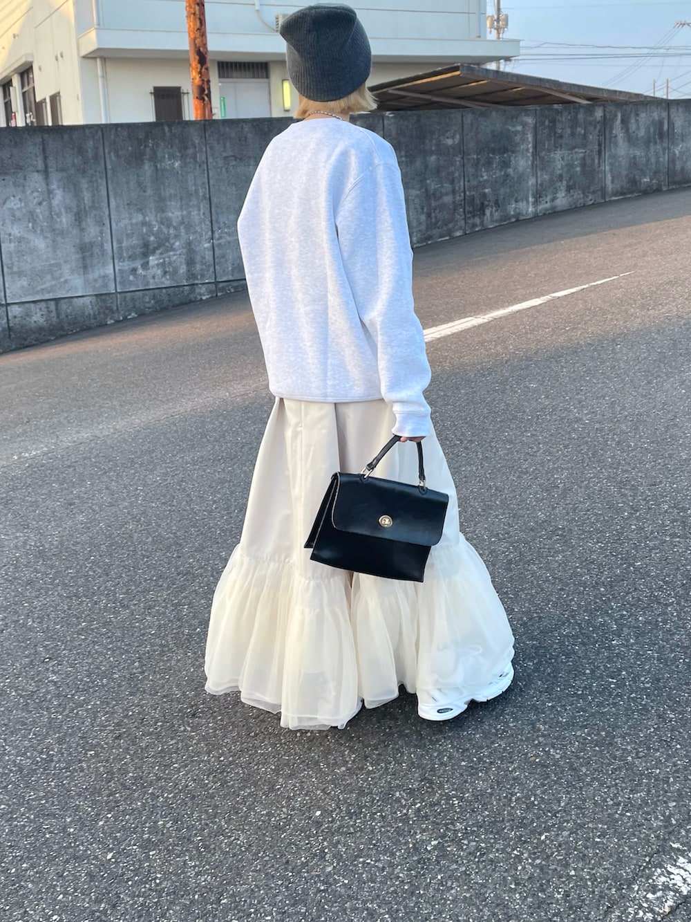 グレー系のスウェット、ホワイト系のワンピースを着用したレディースの冬コーディネートの3枚目の写真