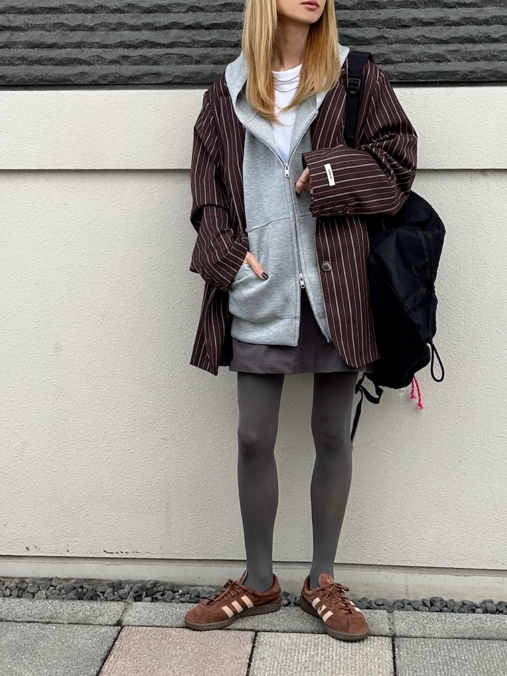 ブラウン系のテーラードジャケット、グレー系のパーカーを着用したレディースの秋コーディネートの4枚目の写真