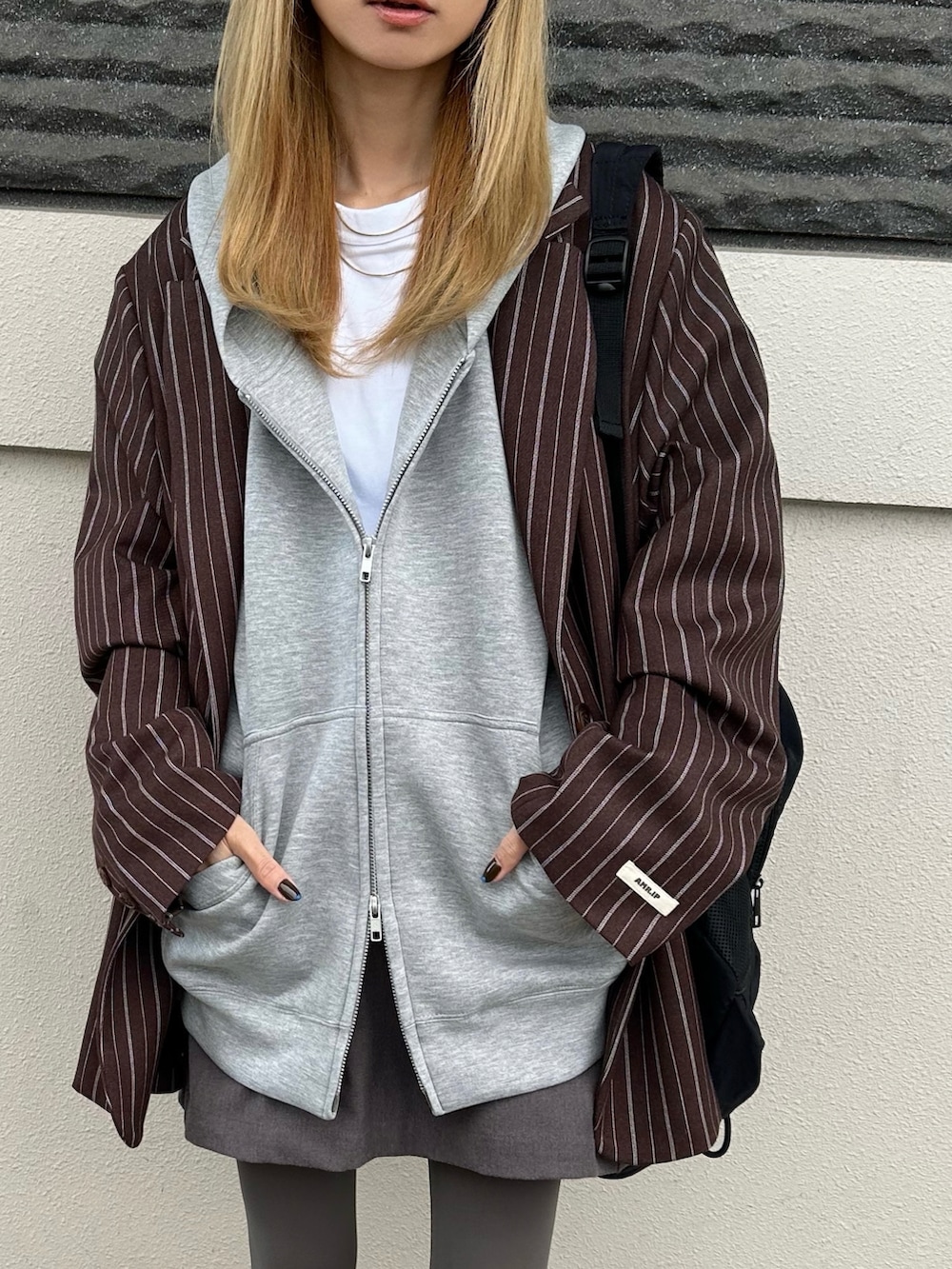 ブラウン系のテーラードジャケット、グレー系のパーカーを着用したレディースの秋コーディネートの2枚目の写真