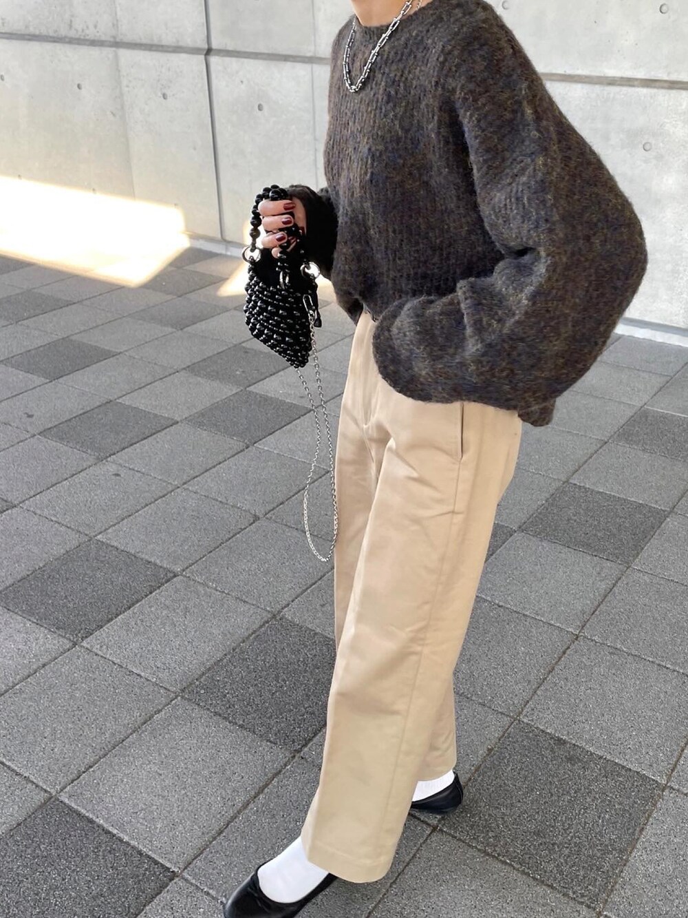 ブラウン系のニット/セーター、ベージュ系のチノパンツを着用したレディースの冬コーディネートの3枚目の写真