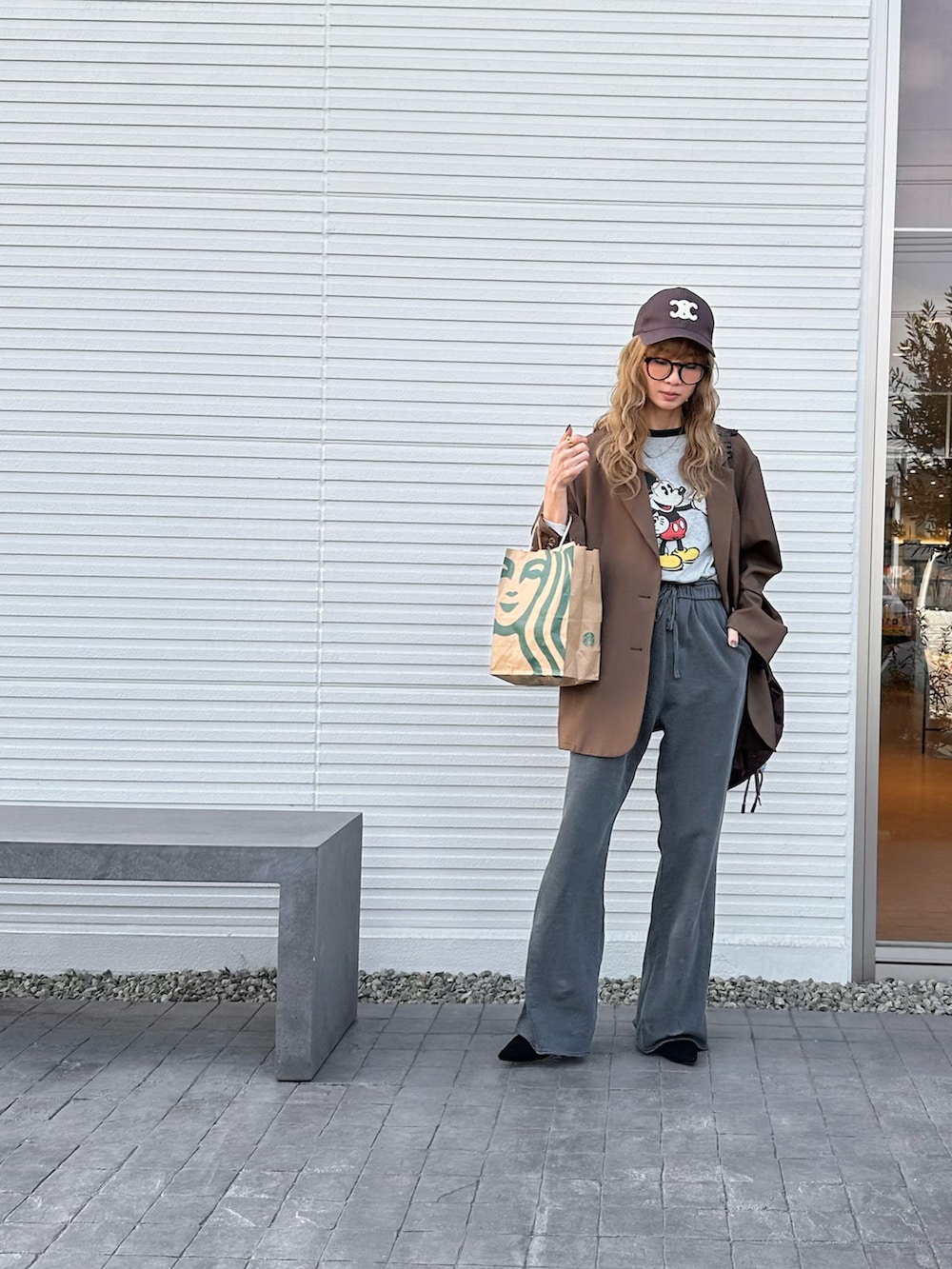 ブラウン系のテーラードジャケット、ブラウン系のバックパック/リュック、グレー系のスウェットパンツを着用したレディースの春コーディネートの2枚目の写真