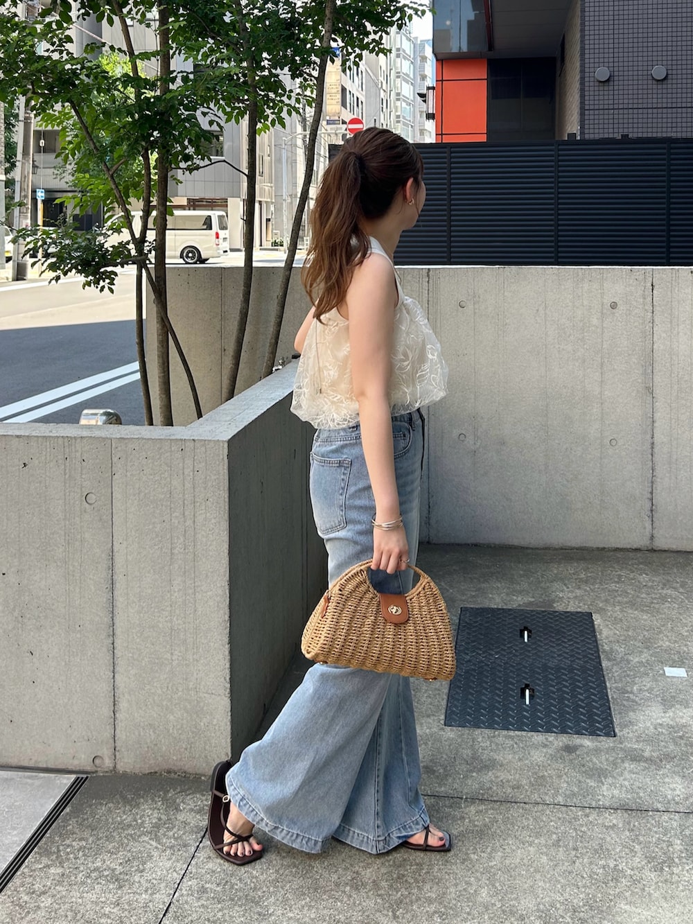 ベージュ系のキャミソール、ブルー系のデニムパンツ、ホワイト系のサンダルを着用したレディースの夏コーディネートの3枚目の写真