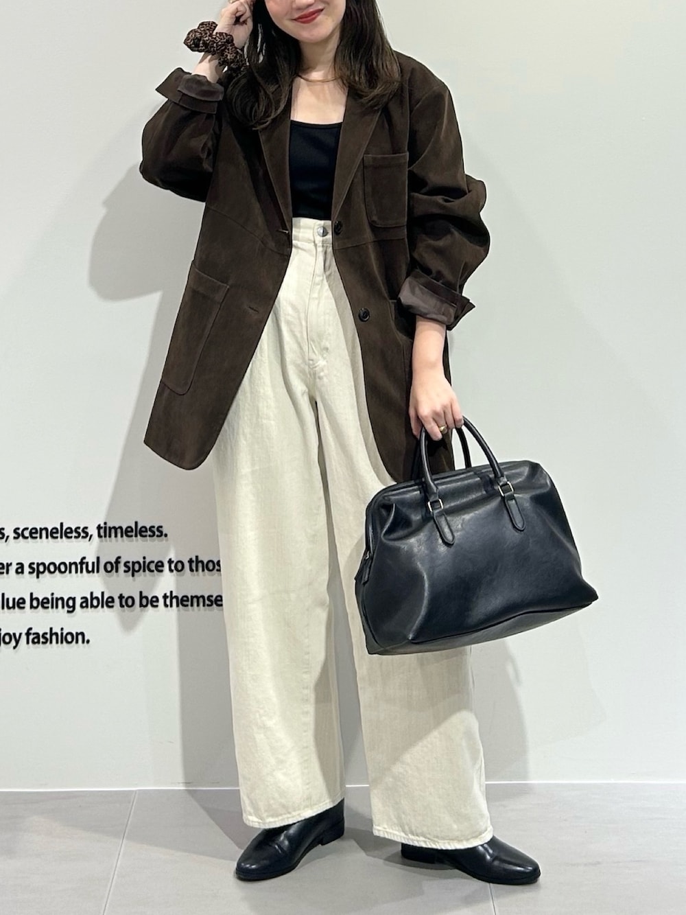 ブラウン系のその他アウター、ホワイト系のその他パンツ、ブラック系のボストンバッグを着用したレディースの秋コーディネートの2枚目の写真