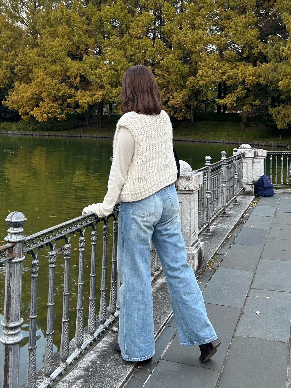 ホワイト系のベスト、ブルー系のスラックス、ホワイト系のTシャツ/カットソーを着用したレディースの秋コーディネートの3枚目の写真