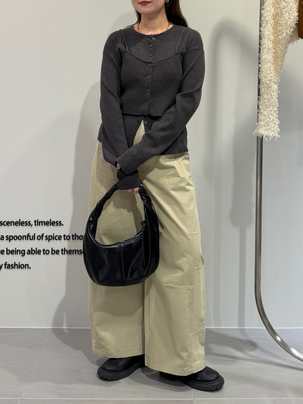 グレー系のニット/セーター、ベージュ系のその他パンツ、ブラック系のハンドバッグを着用したレディースの秋コーディネートの2枚目の写真