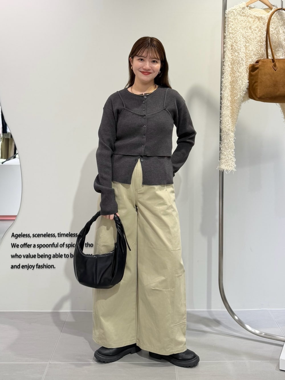 グレー系のニット/セーター、ベージュ系のその他パンツ、ブラック系のハンドバッグを着用したレディースの秋コーディネートの4枚目の写真