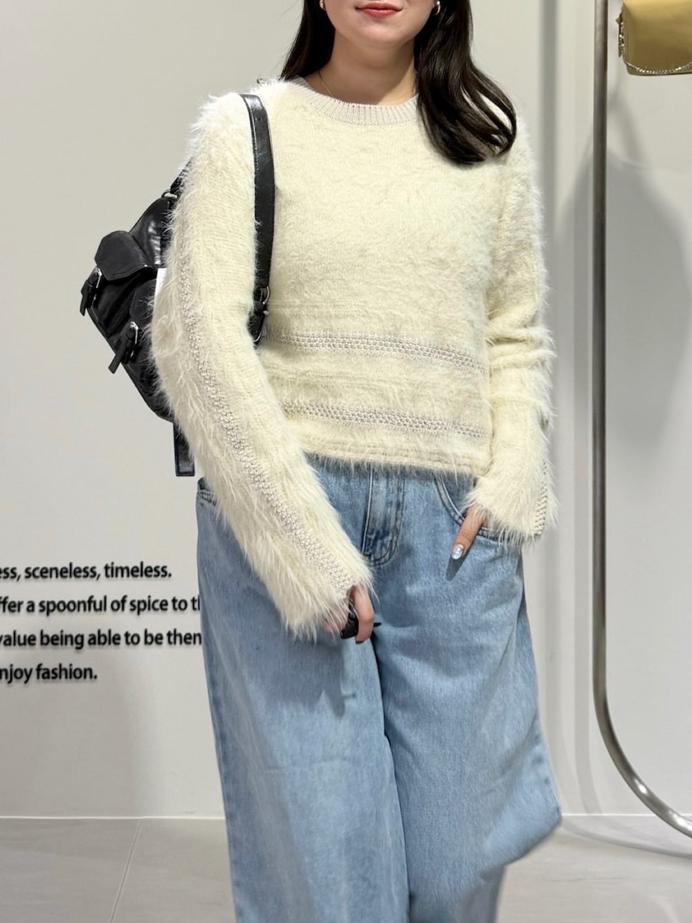 ホワイト系のニット/セーター、ブルー系のデニムパンツ、ブラウン系のショルダーバッグを着用したレディースの冬コーディネートの3枚目の写真