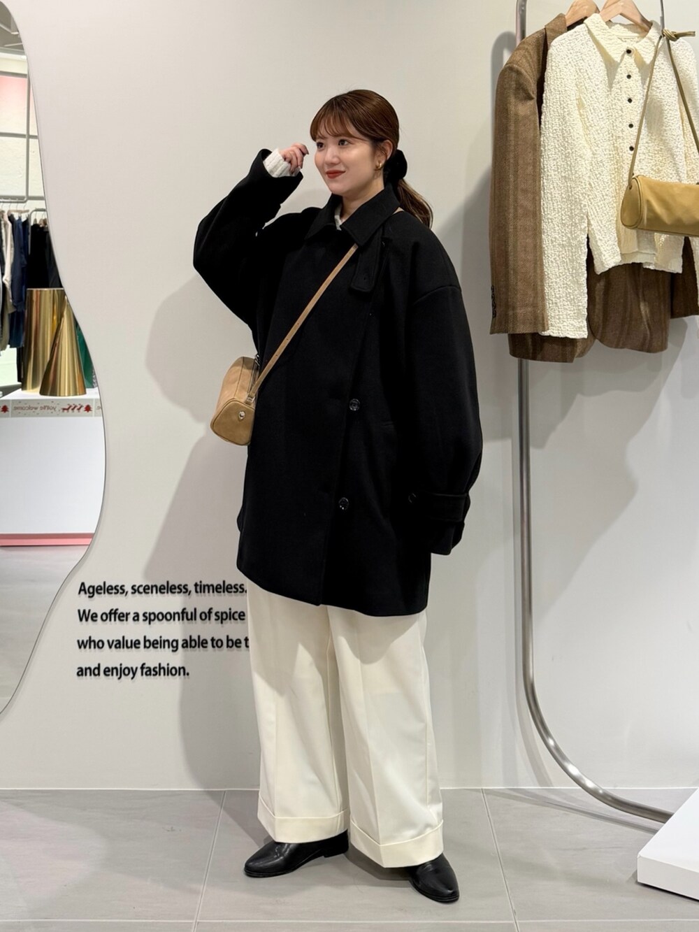 ブラック系のその他アウター、ホワイト系のその他パンツ、イエロー系のショルダーバッグを着用したレディースの冬コーディネートの4枚目の写真